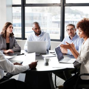 istockphoto-1146472948-612×612 Millennial black businesswoman addressing colleagues at a corporate business meeting, close up