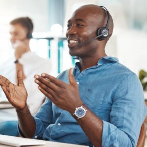 istockphoto-1441351094-612×612 Call center, telemarketing and customer service with a business man working in an office and consulting on a headset. Help, crm and contact us with a male consult at work on a computer by his desk