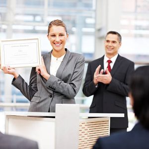 Businesswoman stands up on stage and shows off an award. Horizontal shot. Businesswoman stands up on stage and shows off an award. Horizontal shot.